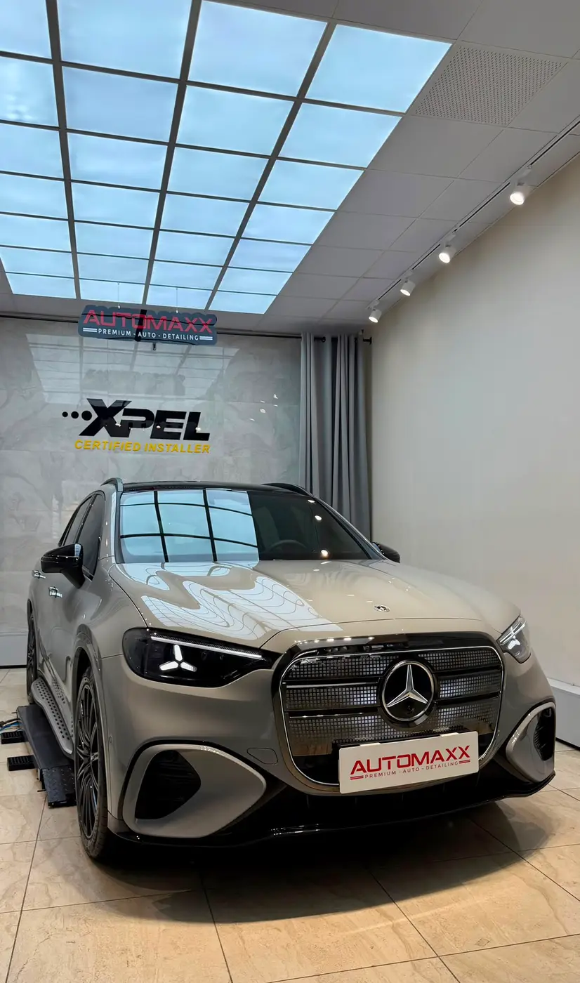 Automaxx atölyesinde bej renkli Mercedes GLC; arkada AUTOMAXX ve XPEL Certified Installer duvarı