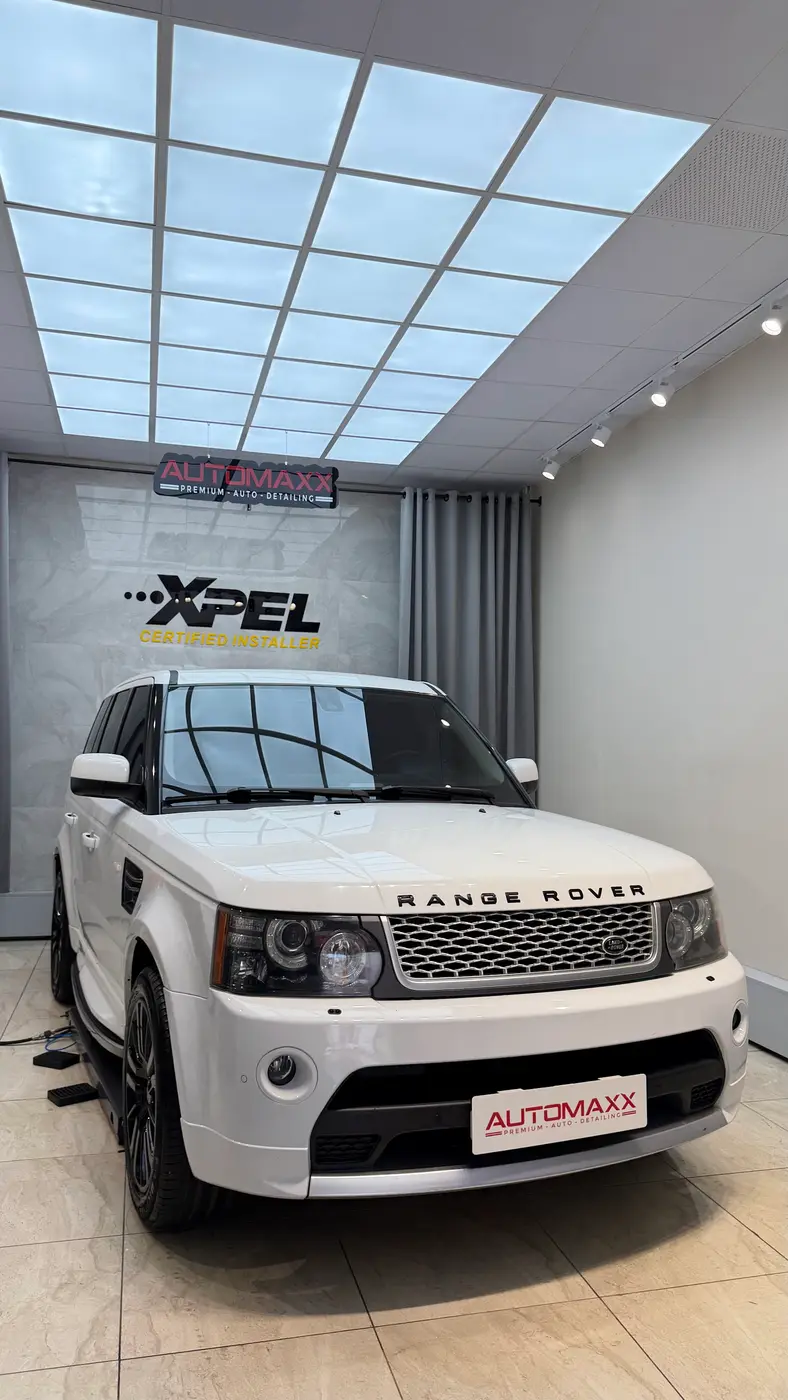 XPEL Certified Installer duvarının önünde beyaz Range Rover